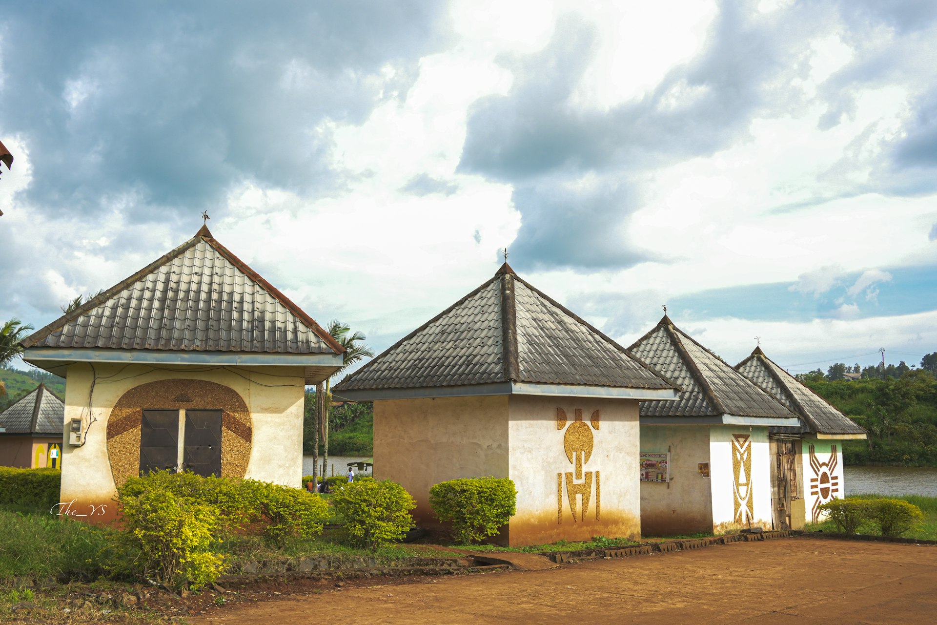 A couple of houses sitting on top of a lush green field